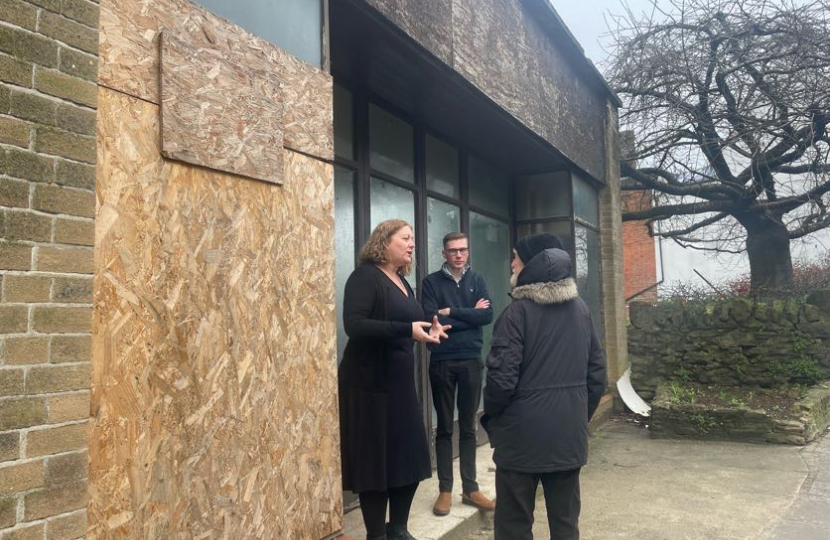 Faye Purbrick and Cllr Tom Power talking to a resident outside a boarded up shop on Wincanton High Street